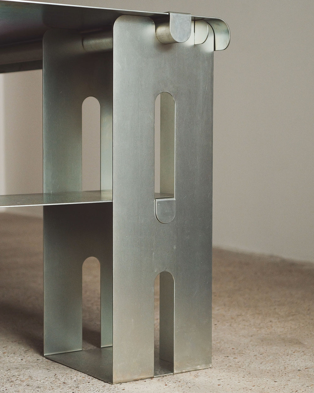 Metallic table leg with geometric design on a neutral background