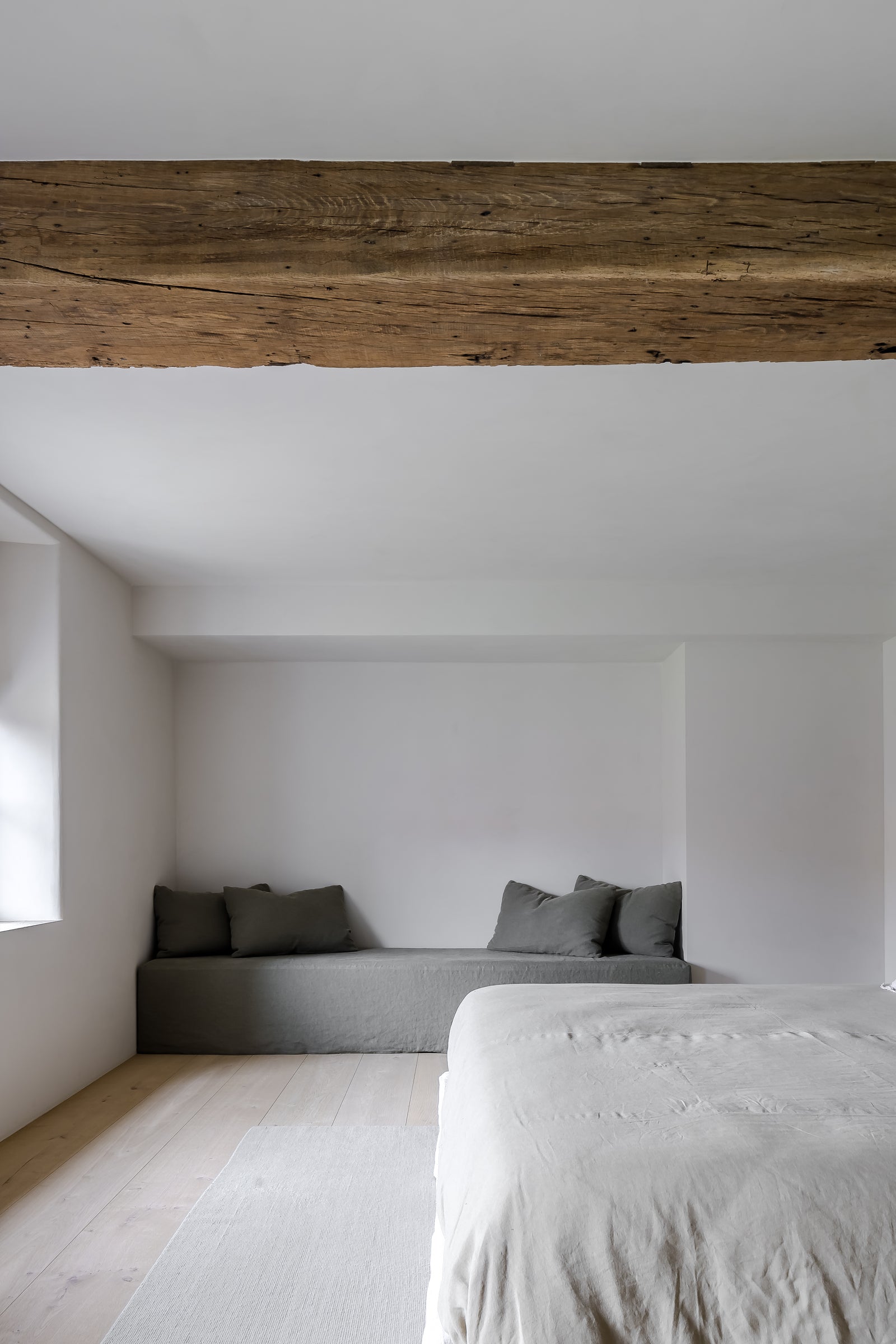 Modern bedroom with wooden beam and minimal furniture
