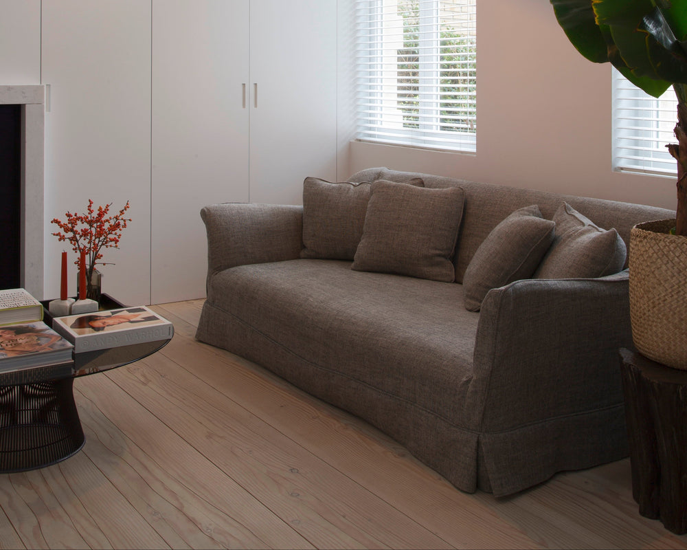 Modern living room with a gray sofa, wall-mounted lamp, and decorative items.
